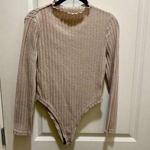 A beige tan bodysuit, long sleeves